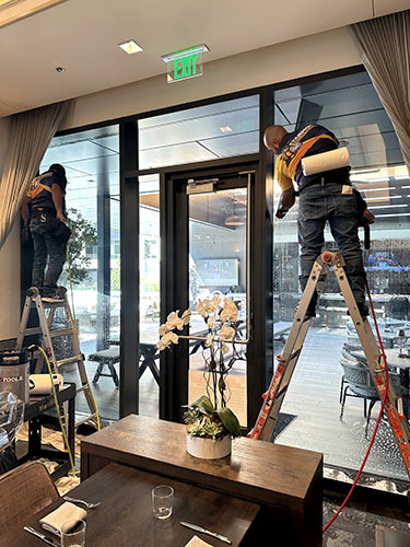 Starmor installation team applying 3M Window Film to the windows of a restaurant in Arlington, TX